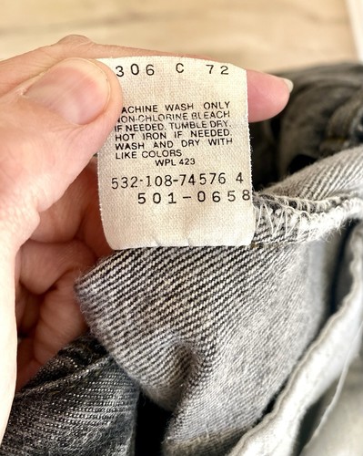 White Levi’s tag on 42x34 black jeans, gray fabric, yellow printed wash instructions and product details.