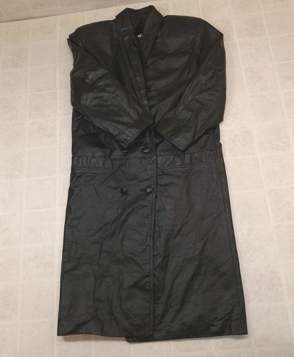 Black vintage leather trench coat with wide shoulder pads, double-breasted buttons, and notched collar on hanger.