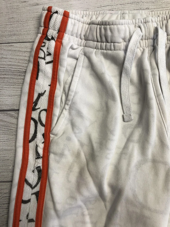 Pantalones deportivos Nike jóvenes grandes blancos a rayas laterales naranja con parche con logotipo Foto 2 de 4