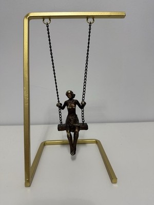 Decorative metal swing girl figurine for home or office decor.