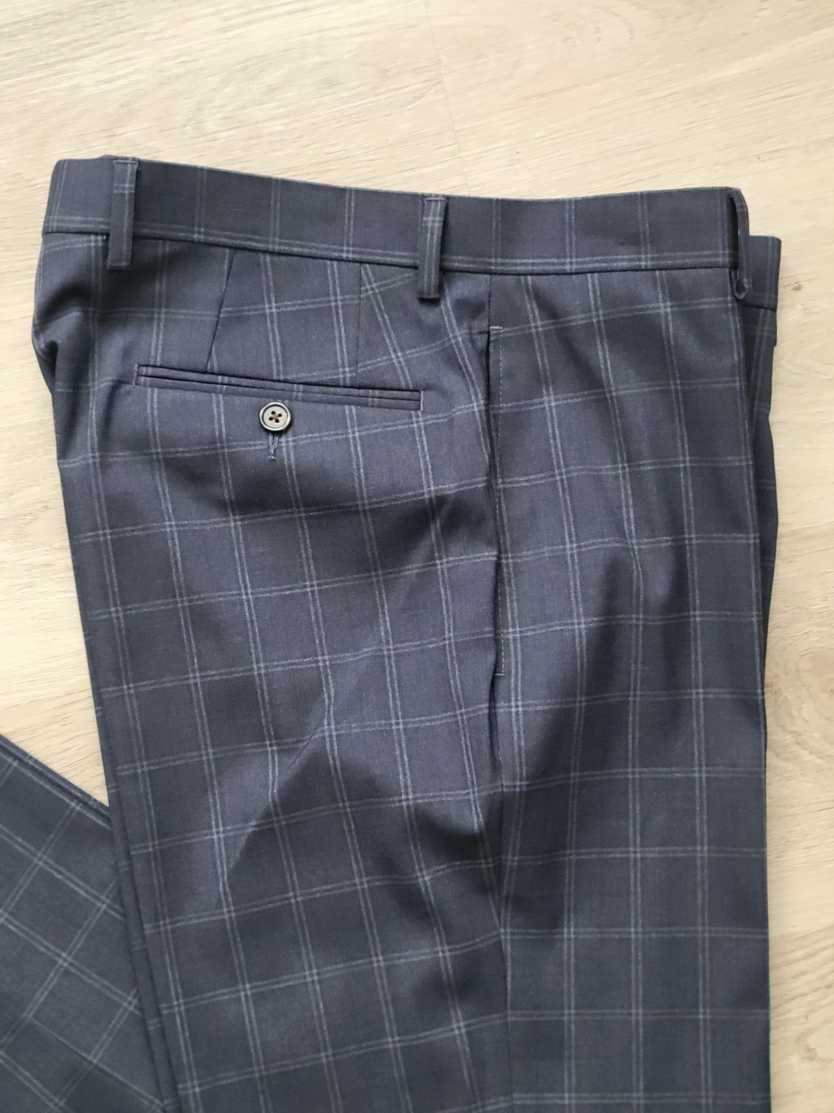 Gray plaid Ralph Lauren men’s flat front dress pants, size 32W x 30L, with button closure and side pockets on light wood floor.