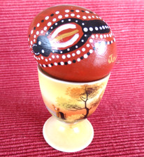 Painted chicken egg plus a decorated ceramic egg cup.