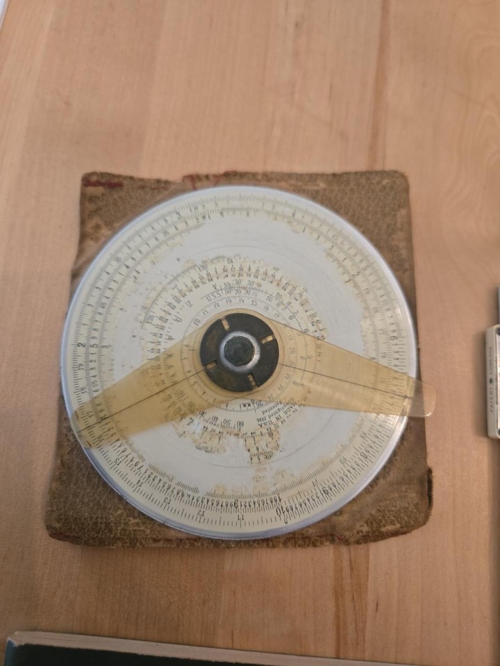 A 1936 Gilson Midget circular slide rule — a circular 'wheel of math' that fits in your pocket and predates every calculator by decades.