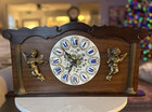 Wooden mantel clock with porcelain dial and gilt bronze cherub decorations — photo 1