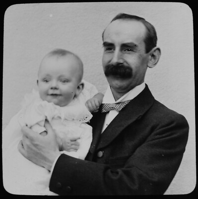 Magische Laternenrutsche MANN MIT HERRLICHEM SCHNURRBART HOLIDNG BABY UM 1910 FOTO