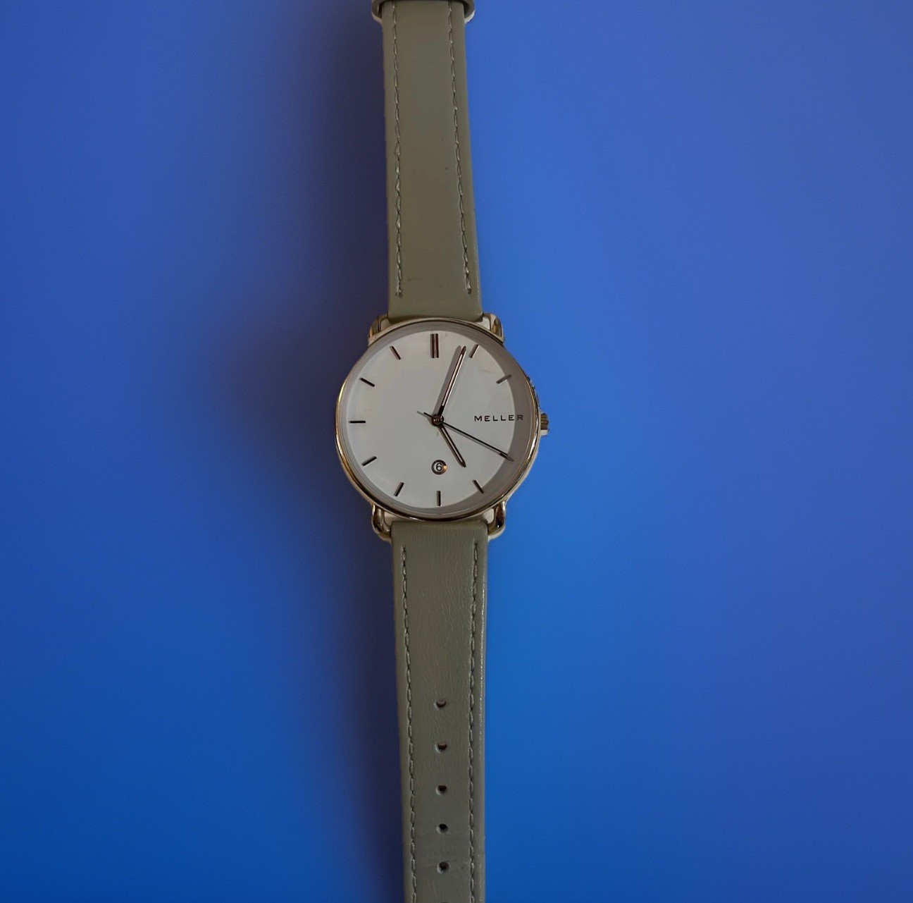 Reloj Meller para dama tono oro rosa esfera blanca fecha correa de cuero gris