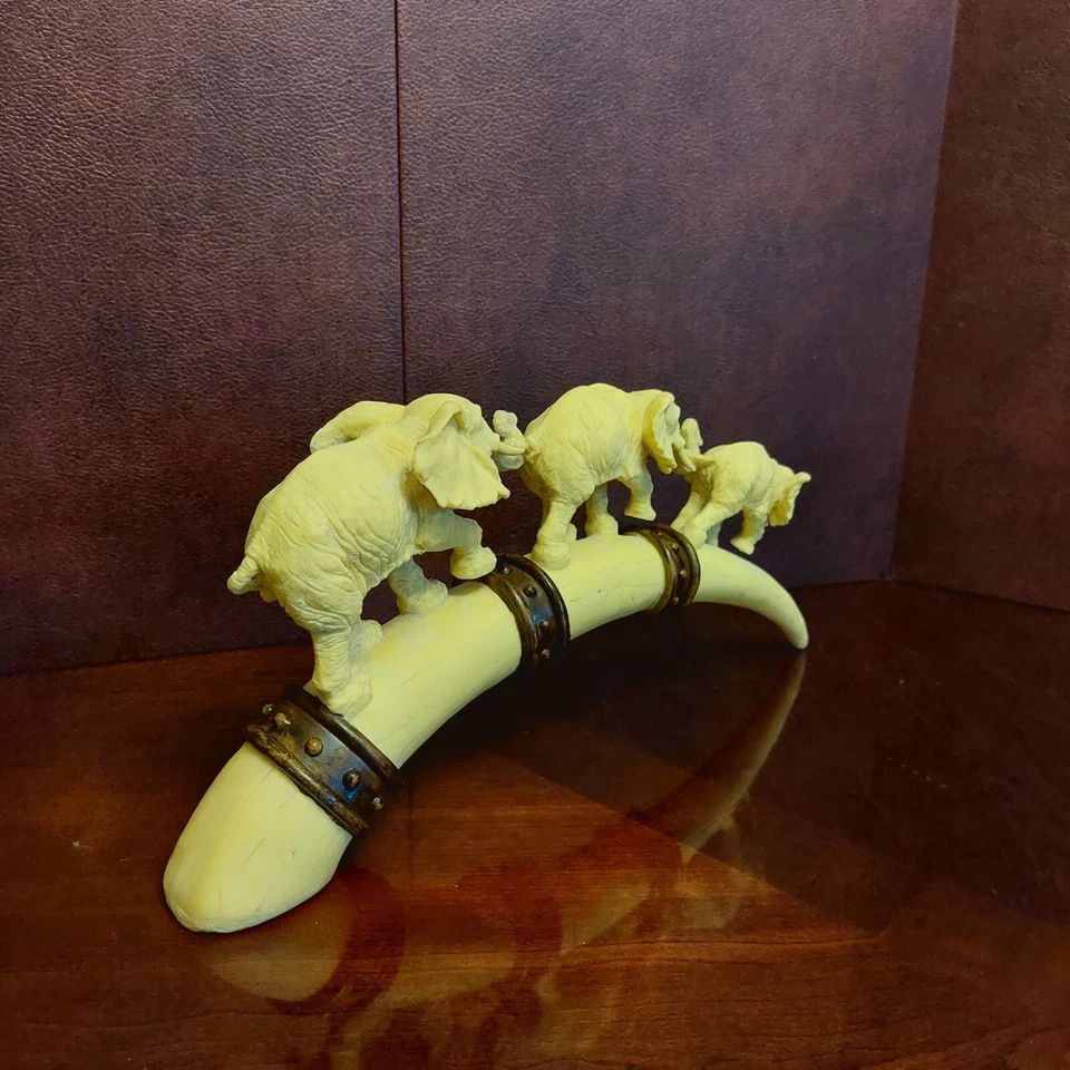 Escultura familiar de elefantes, ternero, mamá y papá caminando sobre puente formas como un colmillo Foto 2 de 4