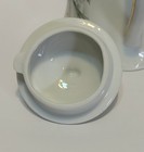 White porcelain teapot with lid, gold rim, and floral design; made in USA.