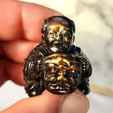 Brass Budha holding a mask finial decoration adds peace and tranquility