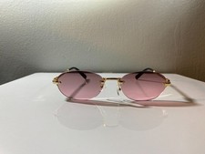 Unisex, rimless, oval shaped sunglasses with lavender lenses and gold frame