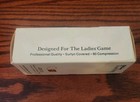 White rectangular Wilson box with orange ladybug logo and text reading “Designed For The Ladies’ Game” on wooden surface.