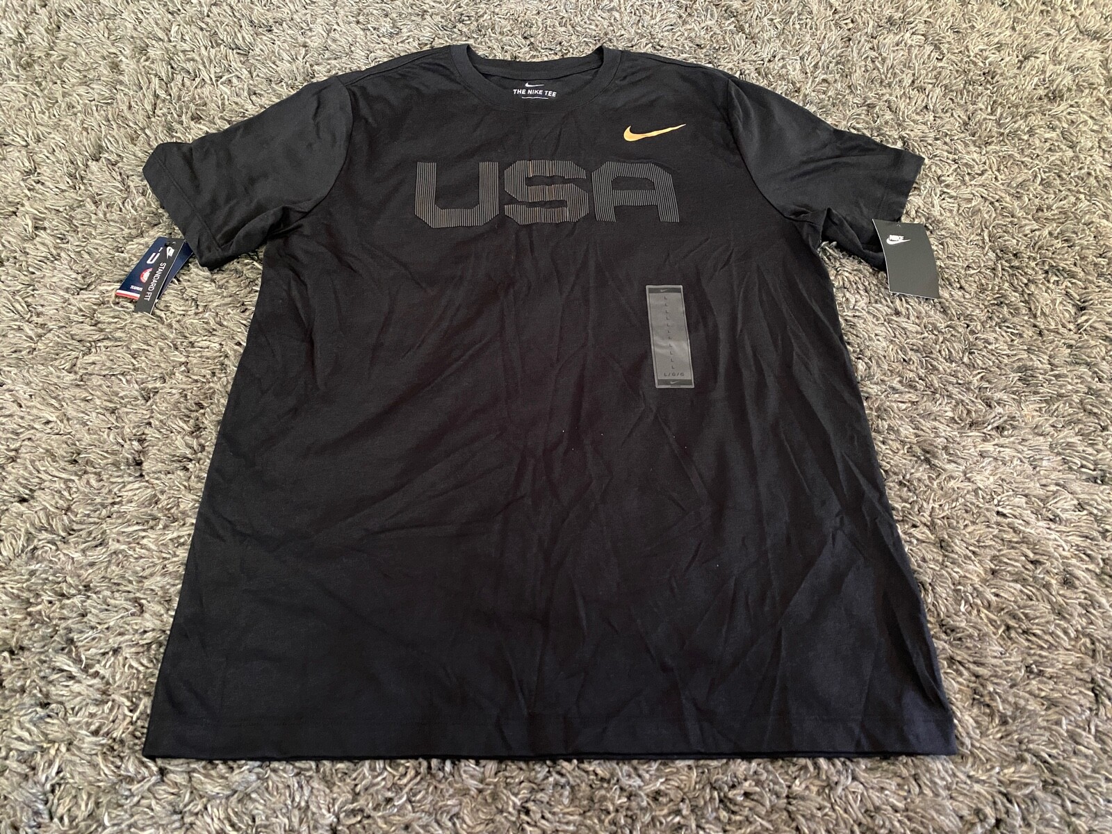 black nike shirt with gold swoosh