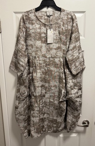 Gray linen long sleeve dress with subtle textured pattern, round neckline, and front pockets, hanging on black hanger.