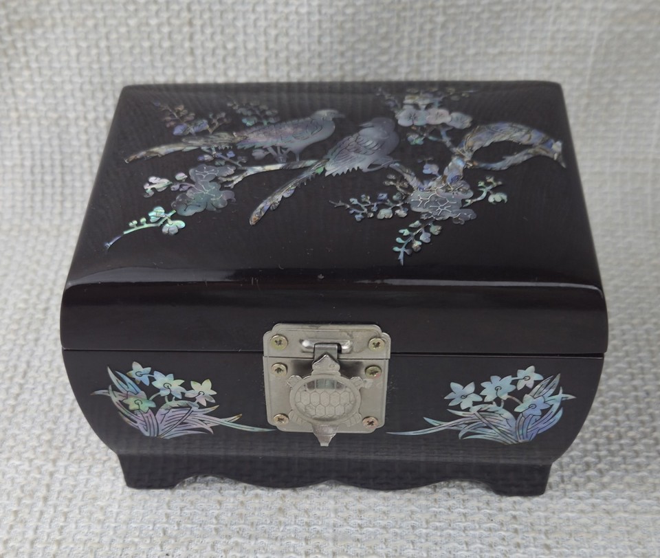 A lacquered mother-of-pearl inlay jewelry music box with a Sankyo movement — stunning Asian craftsmanship that doubles as decor.
