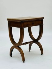 Table à jeux XIXᵉ style Empire en acajou, piètement en X, tiroir et roulettes d’