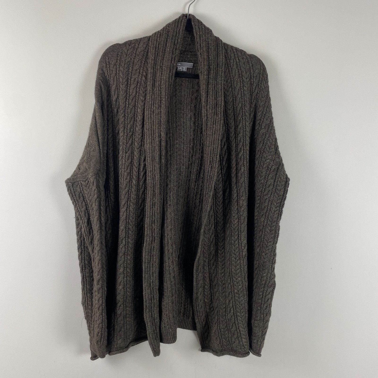 Brown oversized open-front cable-knit cardigan in a yak-alpaca blend, shown on a hanger.