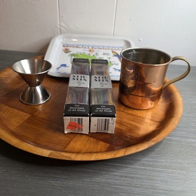 A jigger, two boxes of Stir Styx,decorative tray, and a copper Moscow Mule mug.