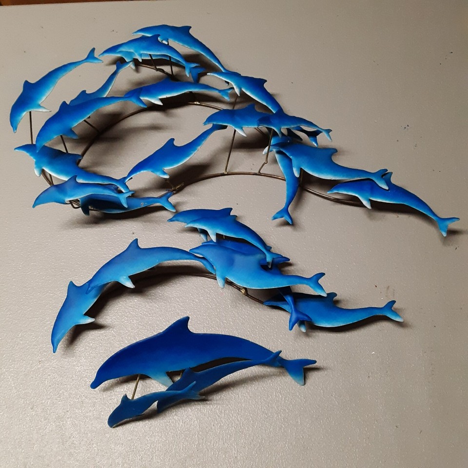 A three-piece MCM metal dolphin wall sculpture — the kind of dramatic, dimensional wall art that makes a room feel like a 1965 split-level dream.