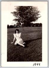 Vtg B&W Snapshot Young Woman Sitting On Grass Patterned Ruffled Dress 1944