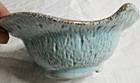 Blue and gold textured bowl with fluted sides, made in USA #146, on white ceramic background.