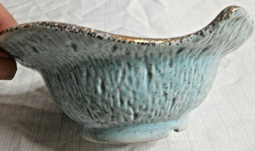 Blue and gold textured bowl with fluted sides, made in USA #146, on white ceramic background.