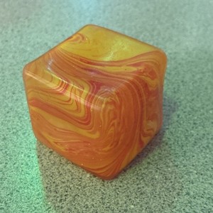 NEEDOH cube swirled marbele red, orange, and yellow two inches six sided NEEDOH 