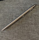 Silver Parker vintage ballpoint with blue ink, made in USA, on textured gray fabric background.