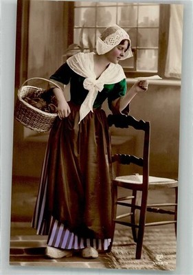 38168073 - A young woman in Dutch costume reads one in the room