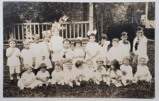 RPPC Cutes Group of Children White Dresses Bows Toys on Lawn c1908 Postcard Z20