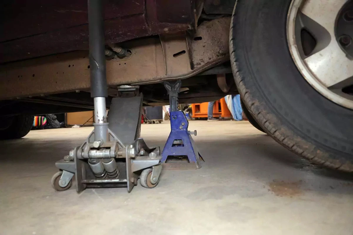 Vehicle lifted with a floor jack and jack stand.