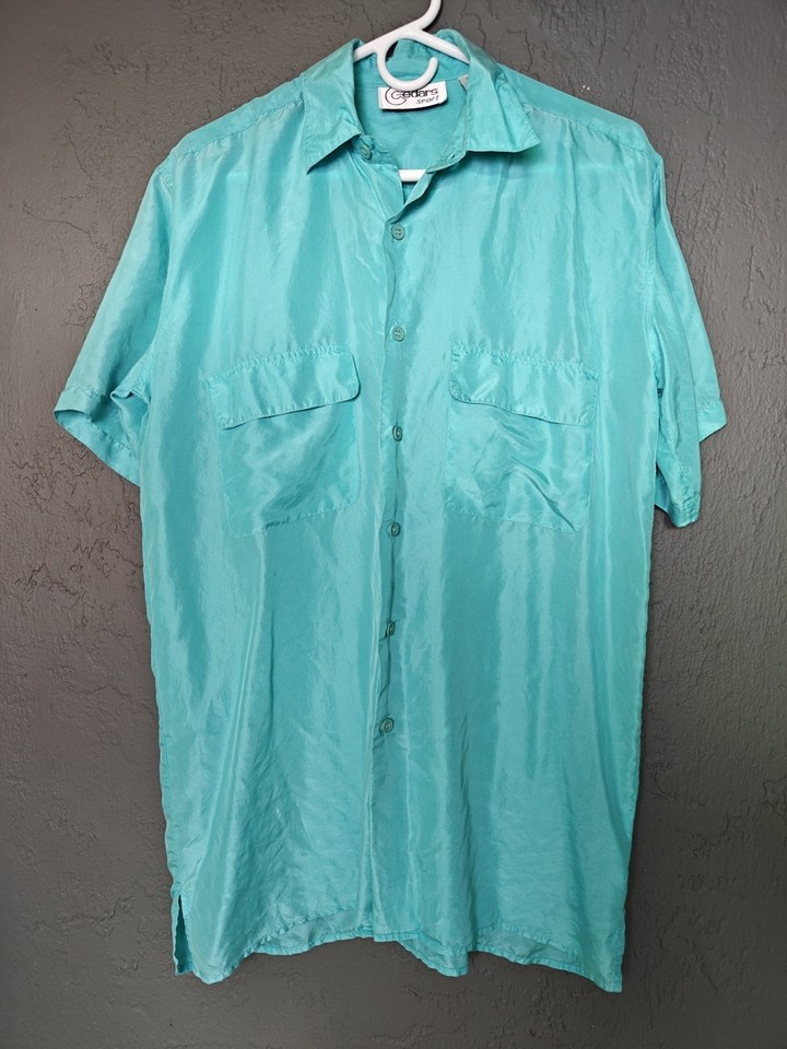 Silky aqua-blue disco-era men's shirt with novelty print — the kind of retro flex that stops a thrift store in its tracks.
