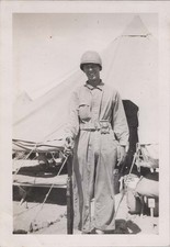 WW2 Photo of Helmeted Soldier Standing Beside Desert Tent Camp