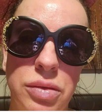 Black Round Sunglasses With Gold Accents On Outer Edges