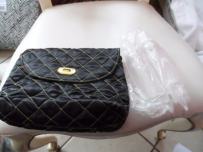 Black quilted cosmetic bag with hot ink lining and 2 plastic shampoo bottles