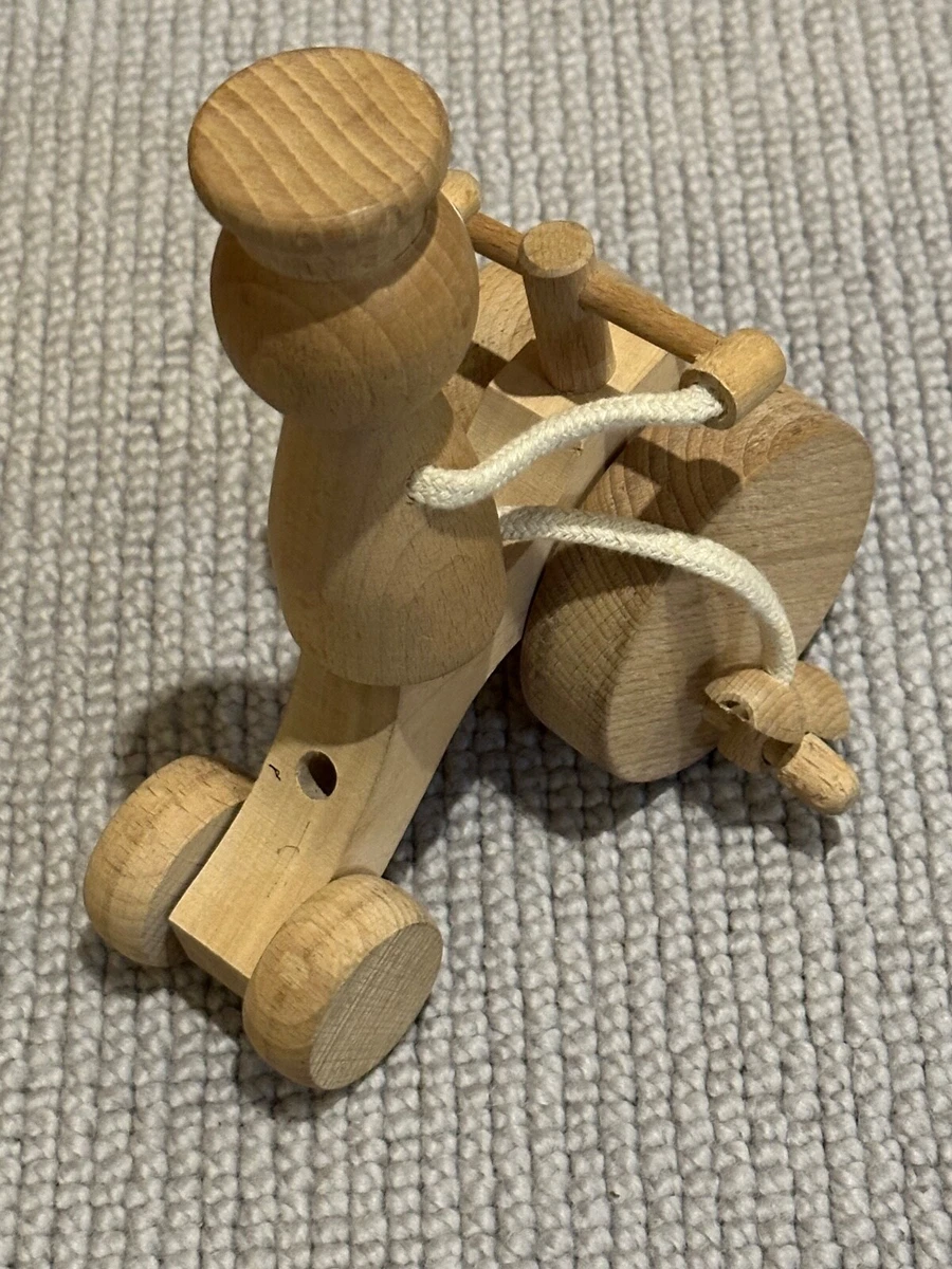 Traditional wooden toy child on tractor bike pedalling