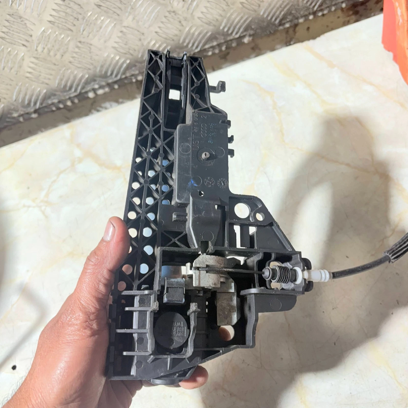 Rear view of Audi A4 exterior handle carrier and Bowden cable