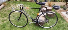 Vintage 1980s Peugeot  road bike with a black steel frame and drop handlebars.