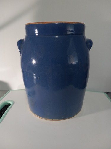 A vintage blue glazed pottery crock with two handles and an unglazed rim. 9"x7"