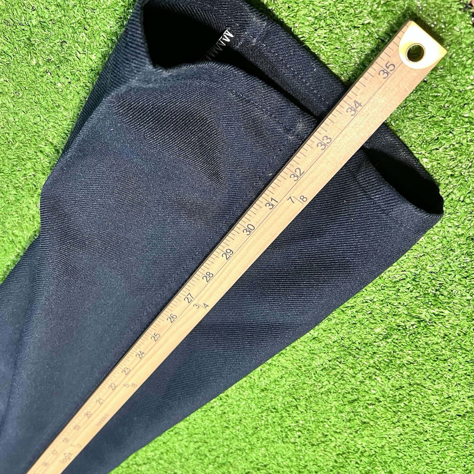 Dark navy blue vintage Wrangler Wrancher 40 x 34 bootcut jeans pants with yellow measuring tape across the waistband.