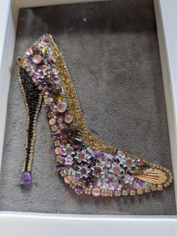 A White 5x7 Shadow Box Frame With A Purple  Shoe Made From Vintage Jewelry