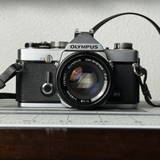 OLYMPUS OM-1n 35MM FILM MANUAL SLR CAMERA WITH 50MM F1.8 LENS READ