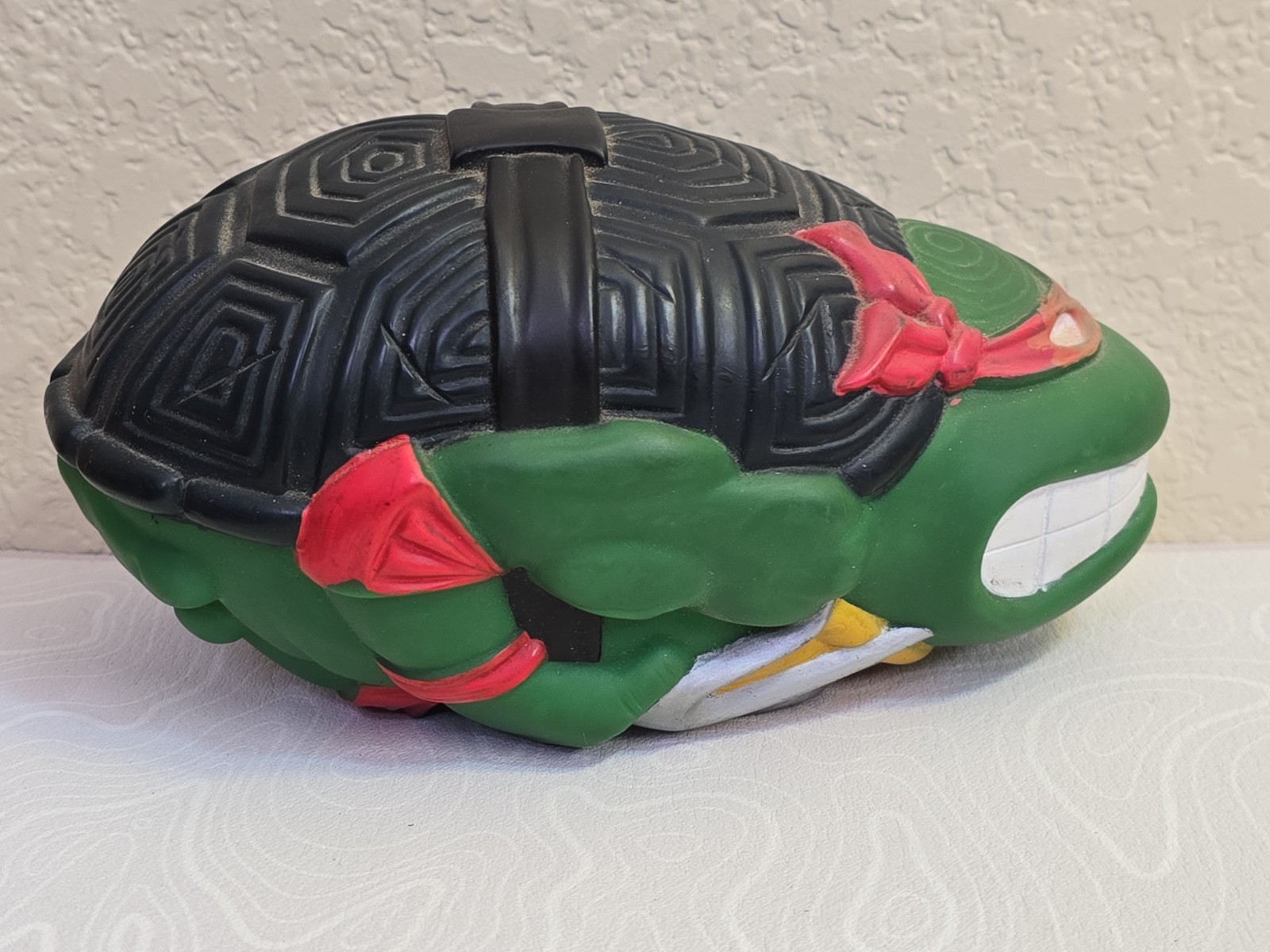 Green 1991 Mirage Studios Teenage Mutant Ninja Turtles Football Raphael with black mask and red tail.