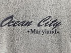 Gray vintage pullover sweater with navy “Ocean City Maryland” text and wavy line accents on chest and shoulders.