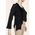 Black asymmetric crop sweater with long sleeves, ribbed trim, and fringe hem, displayed on mannequin wearing tan pants.