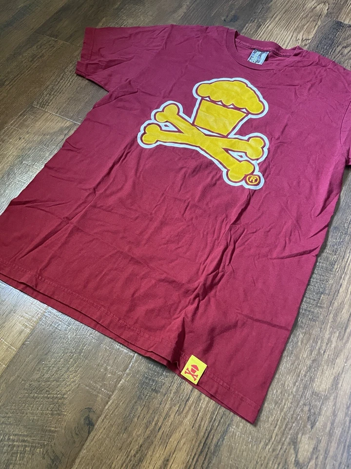 Camiseta Johnny Cupcakes Manga Corta Granate/Amarillo Huesos Cruzados Logo Foto 2 de 4