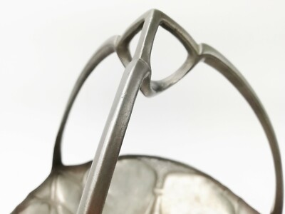 Urania. An Art Nouveau pewter fruit bowl with a loop handle floral decoration