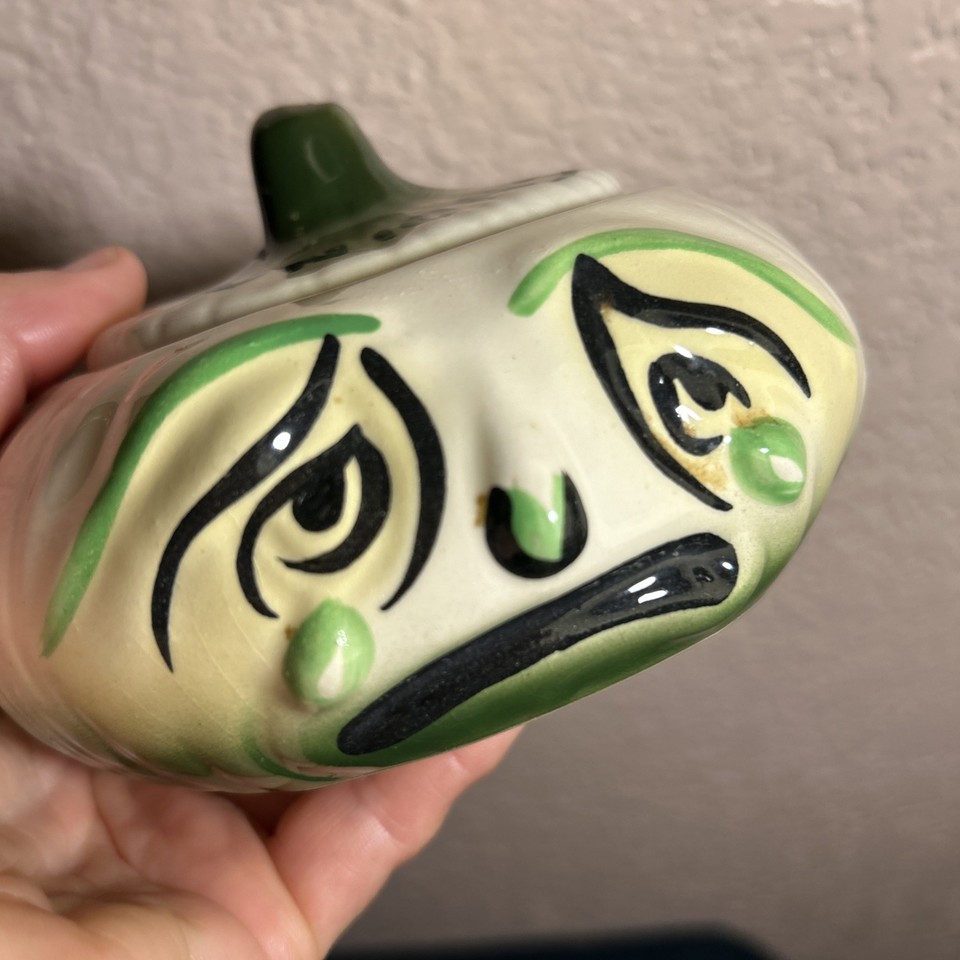 A ceramic onion-shaped storage jar with a goofy face lid — the kind of absurd kitchen character piece that stops people mid-tour of your home.