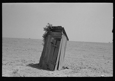 Photo:1930s Desert Outhouse Leaning in Open Field Rural Scene