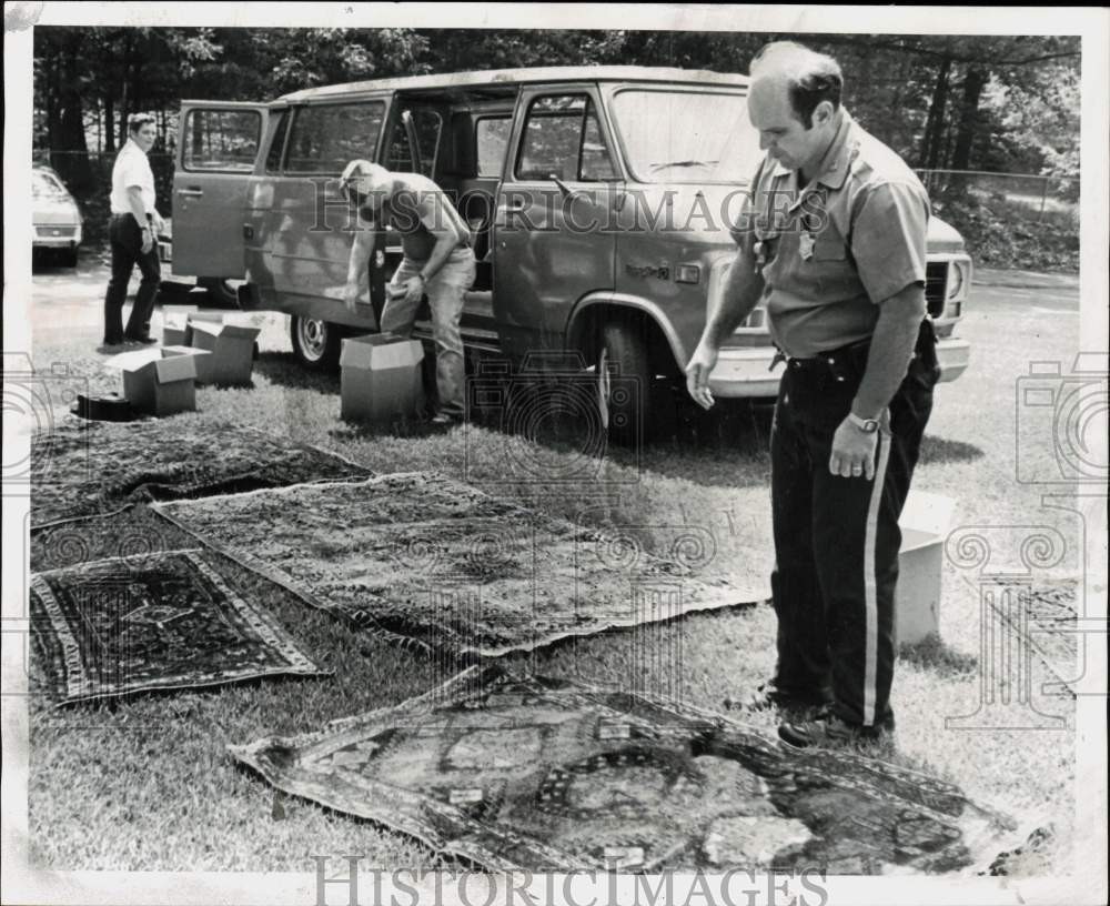 1979 Press Photo Police officer examines Oriental rugs from a stolen van