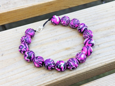 Perlenarmband mit trippigem lila Muster